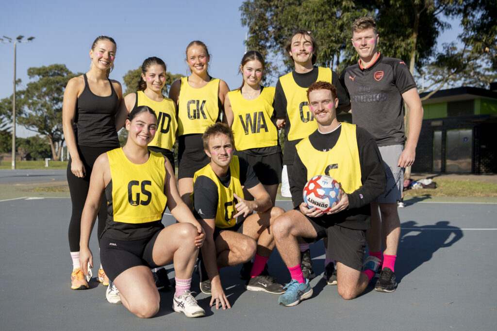 Corporate Year End Events Sydney 8 Corporate team in yellow bibs pose together after a sports event in Sydney